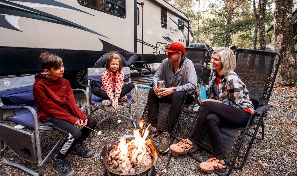 family roasting marshmallows outside thier RV.