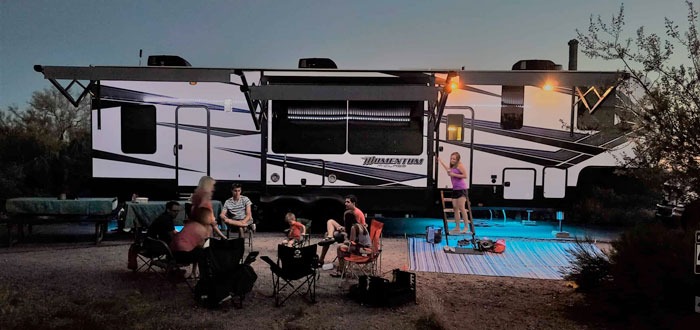 family camping outside a grand design momentum toy hauler