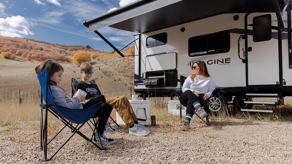 Mom with 2 kids outside Imagine XLS travel Trailer