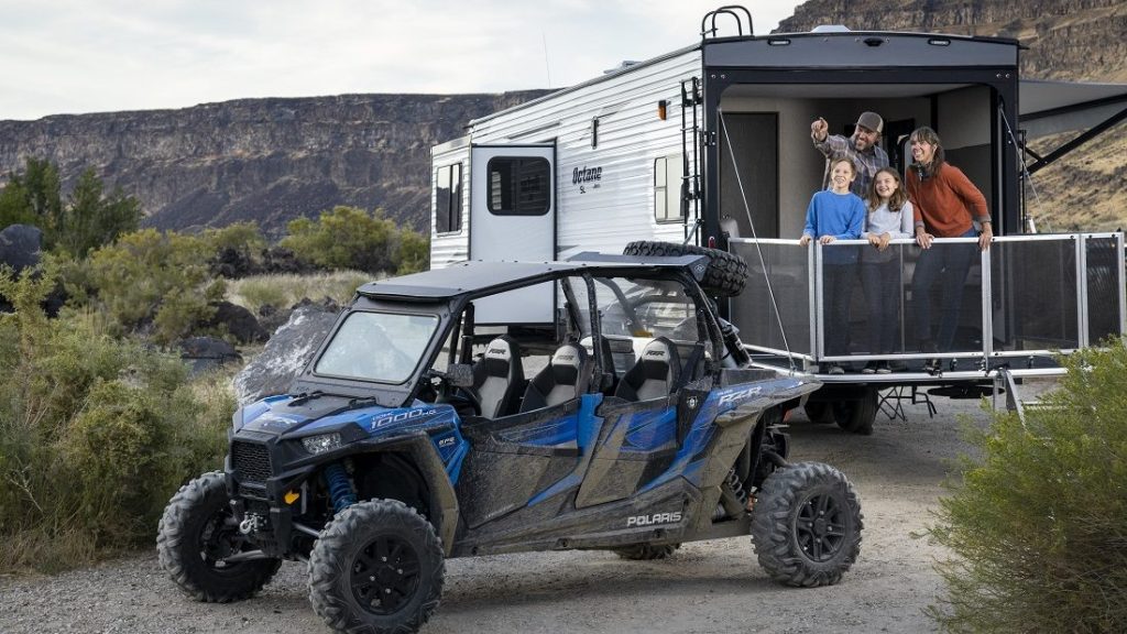 family outside their toyhauler with a 4 wheel side-by-side atv 
