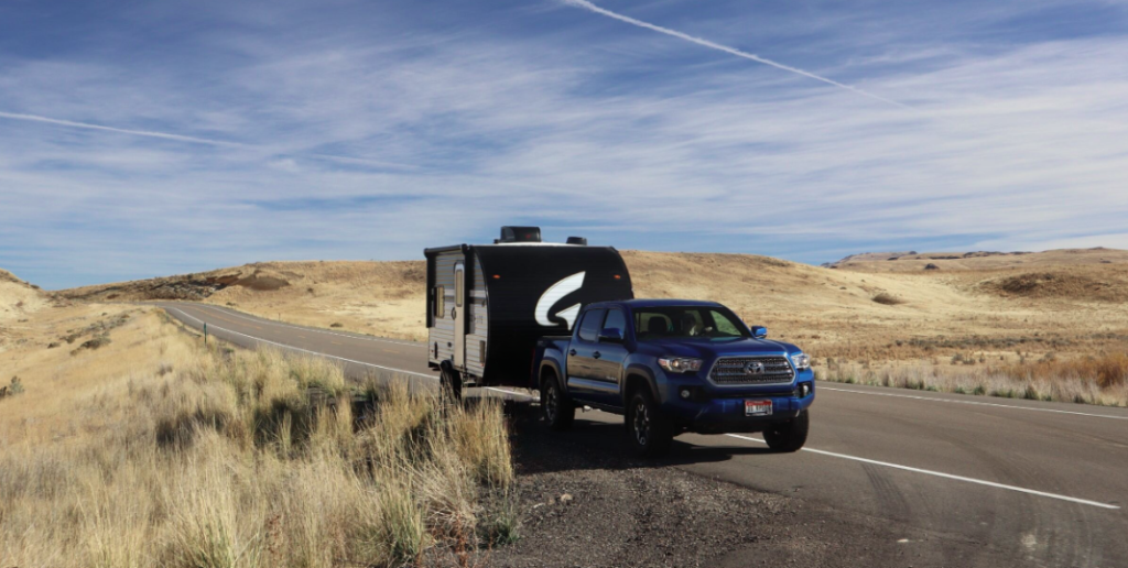 A blue Toyota Tacoma pickup truck towing a black and white travel trailer with a bold "G" logo, parked on the side of a winding road in a vast, open landscape. The terrain features rolling golden hills covered in dry grass under a bright blue sky with wispy clouds and contrails. The remote and scenic backdrop suggests an adventurous road trip or camping excursion in a rural or desert-like setting.



A blue Toyota Tacoma pickup truck towing a black and white travel trailer with a bold "G" logo, parked on the side of a winding road in a vast, open landscape. The terrain features rolling golden hills covered in dry grass under a bright blue sky with wispy clouds and contrails. The remote and scenic backdrop suggests an adventurous road trip or camping excursion in a rural or desert-like setting.




A blue Toyota Tacoma pickup truck towing a black and white travel trailer with a bold "G" logo, parked on the side of a winding road in a vast, open landscape. The terrain features rolling golden hills covered in dry grass under a bright blue sky with wispy clouds and contrails. The remote and scenic backdrop suggests an adventurous road trip or camping excursion in a rural or desert-like setting.






