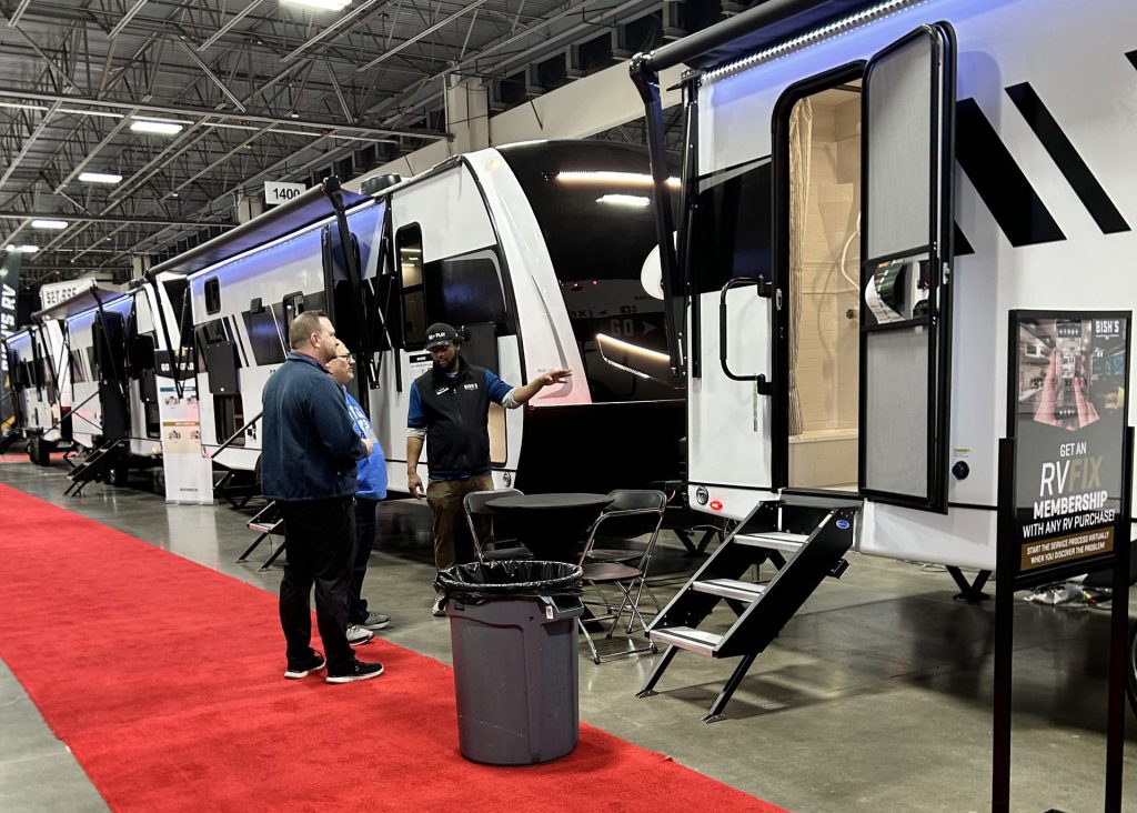 Rv salesman talking to customers about new camper