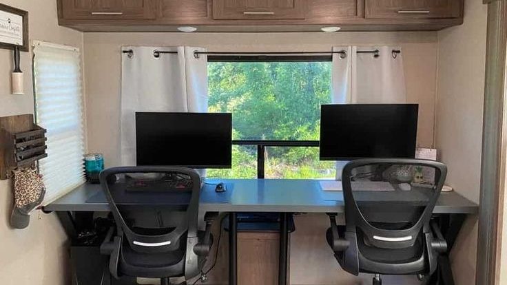 desk in a camper with 2 computers set up with 2 office chairs