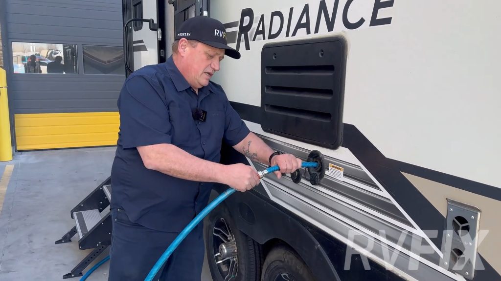 RV tech filling water heater with fresh water - 