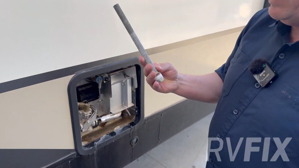 TV tech holding water heater plug and anode rod