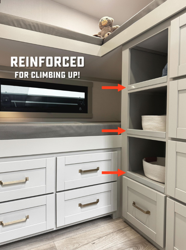  Interior view of a bunk area in a Brinkley RV featuring built-in drawers and open shelving reinforced for safe climbing, with red arrows pointing to support areas and a plush stuffed animal on the upper bunk for a cozy, kid-friendly touch.