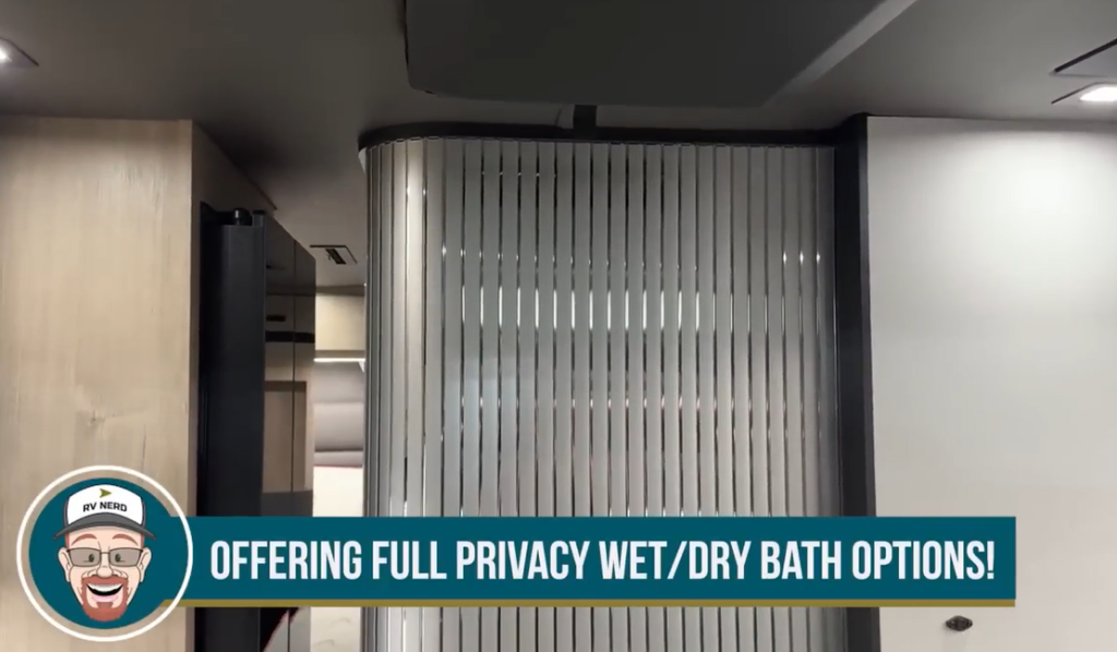 Modern RV shower featuring a sleek black vertical fixture with handheld spray and controls, complemented by a ceiling-mounted rain showerhead and ambient LED lighting, with RV Nerd branding and the caption “AND CEILING MOUNTED RAIN SHOWER!” at the bottom of the image.