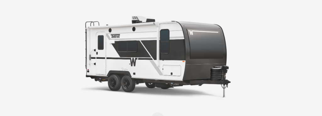 White and black Winnebago Thrive travel trailer with dual axles, panoramic front window, and roof-mounted AC unit, shown on a white background.