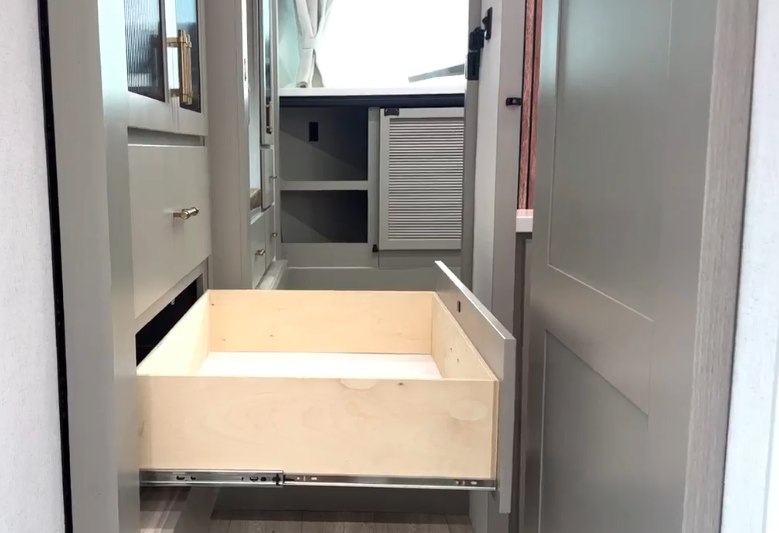 Built-in storage drawer extended in the hallway of the Axiom Imperium 12900 RV, showcasing premium cabinetry and space-efficient design.