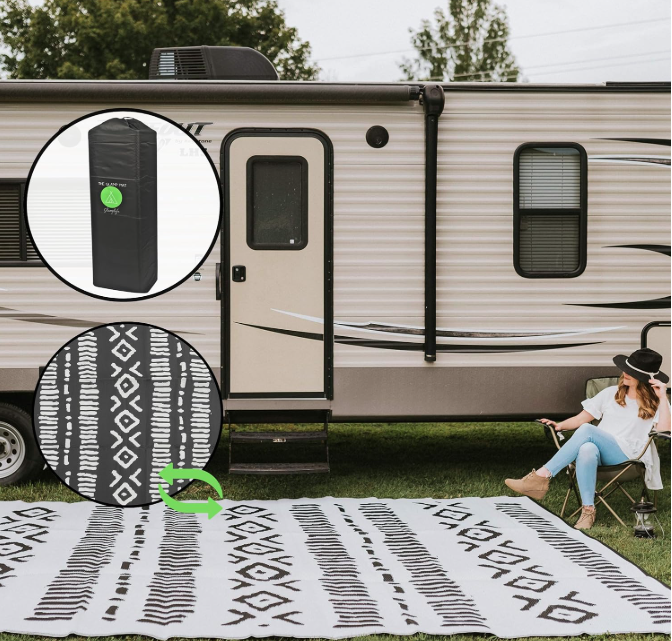 Black and white geometric outdoor RV mat placed outside a travel trailer with a woman relaxing in a camp chair. Inset shows the mat’s reversible design and compact storage bag for easy transport.