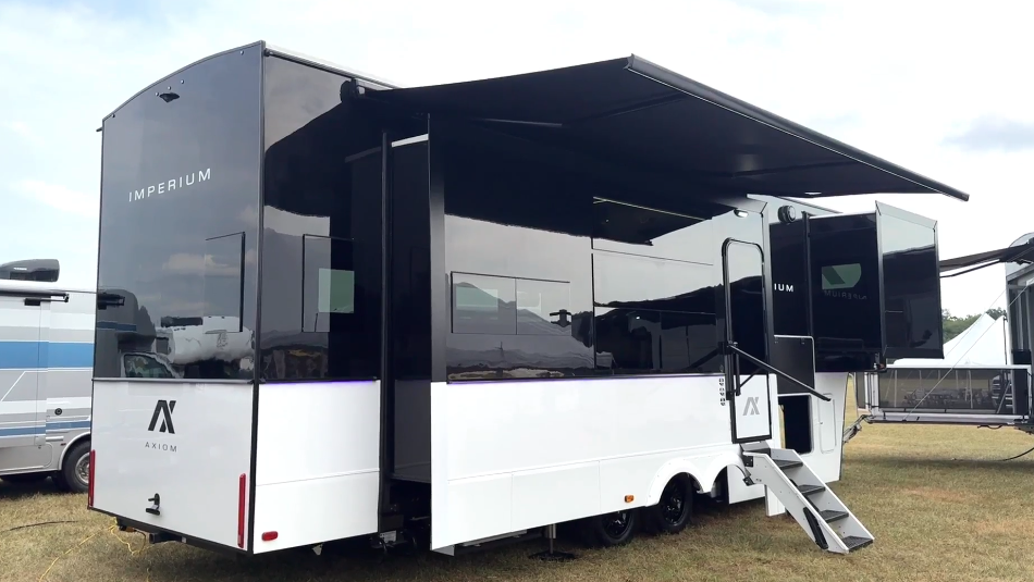 Rear view of the Axiom Imperium 12900 fifth wheel RV with dual slide-outs, large awning, and modern black-and-white exterior design