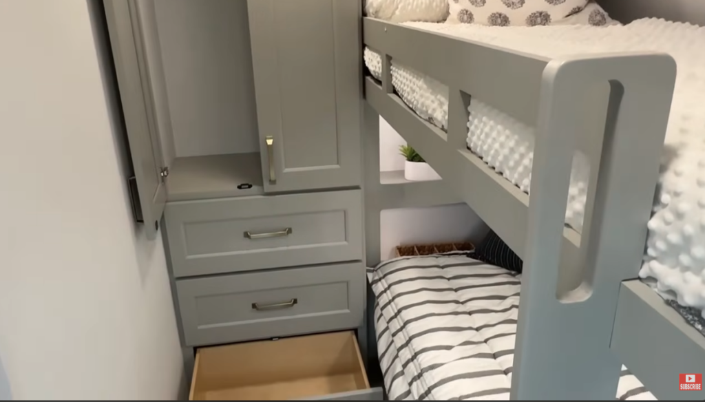 Brinkley RV bunkhouse interior with twin bunk beds, built-in storage cabinets, and pull-out drawers, designed for family-friendly travel comfort.