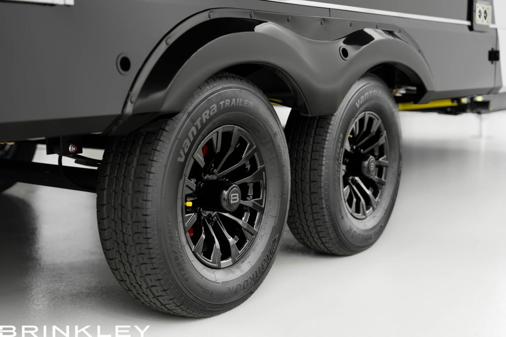 Close-up view of dual Hankook Vantra trailer tires on a Brinkley RV with sleek black alloy rims, showcasing durable construction and modern design for safe towing performance.