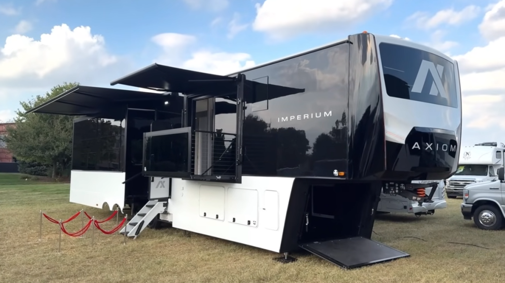 Exterior of the 2026 Axiom Imperium I3800 fifth wheel RV showcasing its striking black-and-white design, dual upper decks, extended slides, and steel-framed construction with luxury residential features.