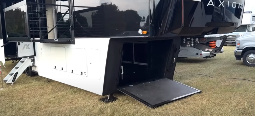 Front storage bay of the 2026 Axiom Imperium I3800 fifth wheel with open hatch door, showcasing its spacious underbelly compartment and steel-structured design for enhanced durability and utility.