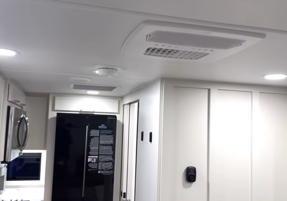 Brinkley Model Ix 20X interior ceiling showing Furrion Chill Q 18K BTU air conditioning system, recessed LED lighting, and modern cabinetry in the luxury travel trailer kitchen.