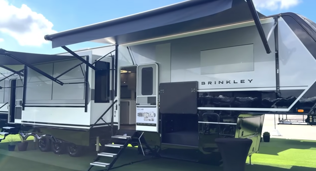 Brinkley Model G Series fifth wheel exterior in white and black with dual power awnings extended, outdoor entertainment setup, and luxury modern body design showcasing premium craftsmanship.
