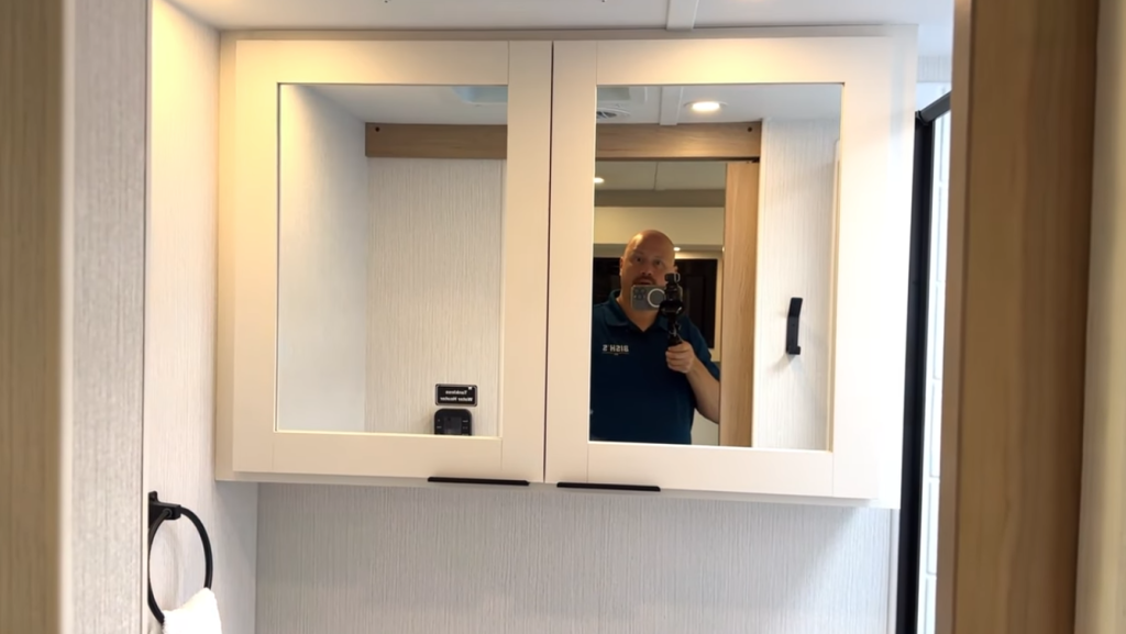 2026 Winnebago Thrive 22MLS bathroom vanity with dual mirrored medicine cabinets, overhead lighting, and modern interior design in a bright, spa-like space.