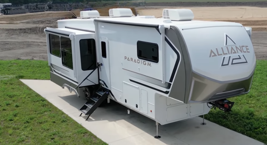Alliance Paradigm fifth wheel RV exterior in white and champagne finish with dual slide-outs extended, showcasing modern aerodynamic front cap, solid entry steps, and luxury residential-style design.