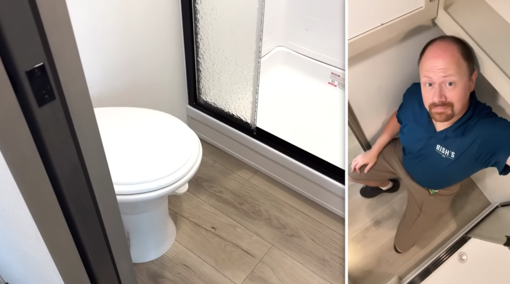 2026 Grand Design Reflection 150 270BN bathroom featuring a porcelain toilet beside a glass shower enclosure, showing ample legroom and modern RV bathroom layout.