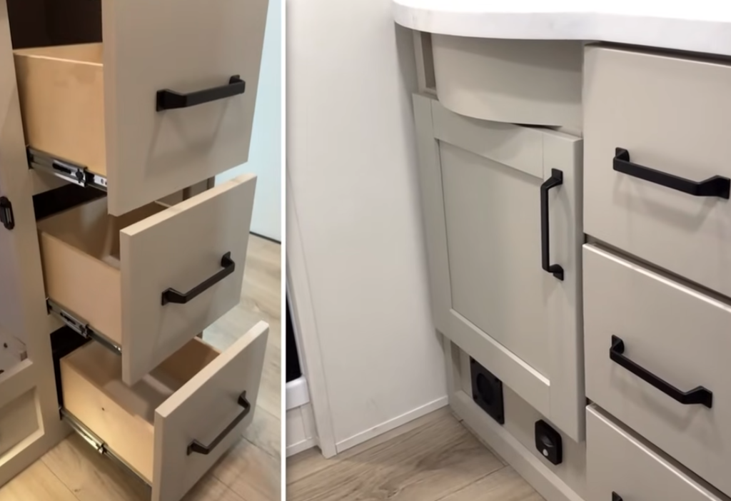 2026 Grand Design Reflection 150 270BN bathroom storage featuring deep pull-out drawers, cabinet space under the sink, and modern black hardware on light cabinetry.