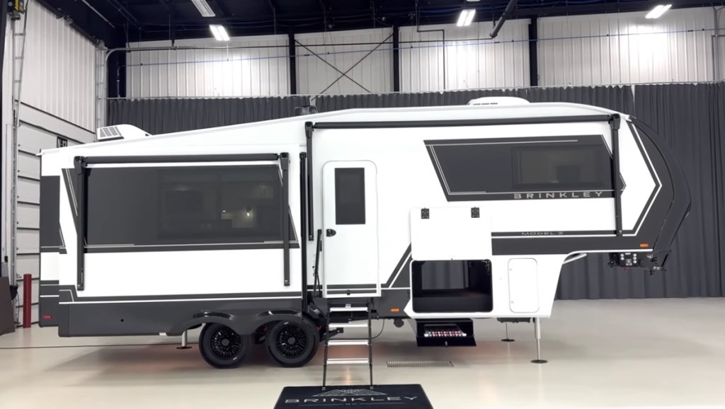 Brinkley Model Z luxury fifth wheel RV side profile showcasing sleek white and charcoal exterior, aerodynamic front cap, dual awnings, and high-end design details for premium modern camping.