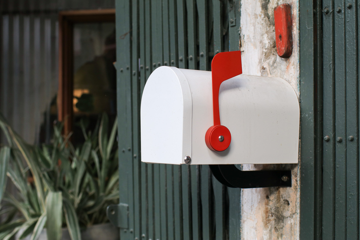 White Mail Box in Front of a House. Mail delivery. Classic traditional residence mailbox hanging on wall