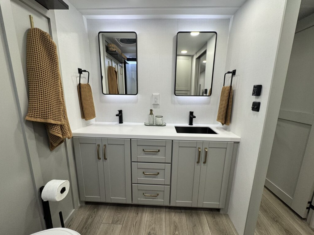 Brinkley Model Z 3600 bathroom vanity with dual lighted mirrors, sleek white countertop, modern black faucets, gray cabinetry, and gold hardware for a clean, residential look.
