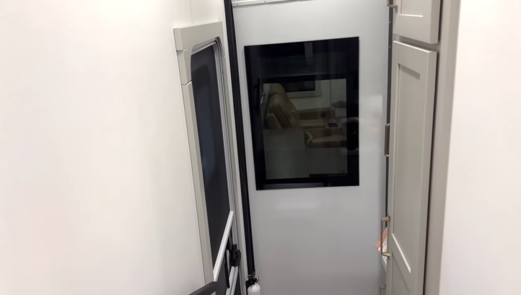 Interior view of the Brinkley Model Z 3600 showing the stairway leading down to the living area, featuring sleek cabinetry, modern trim, and a window view of the lounge seating below.