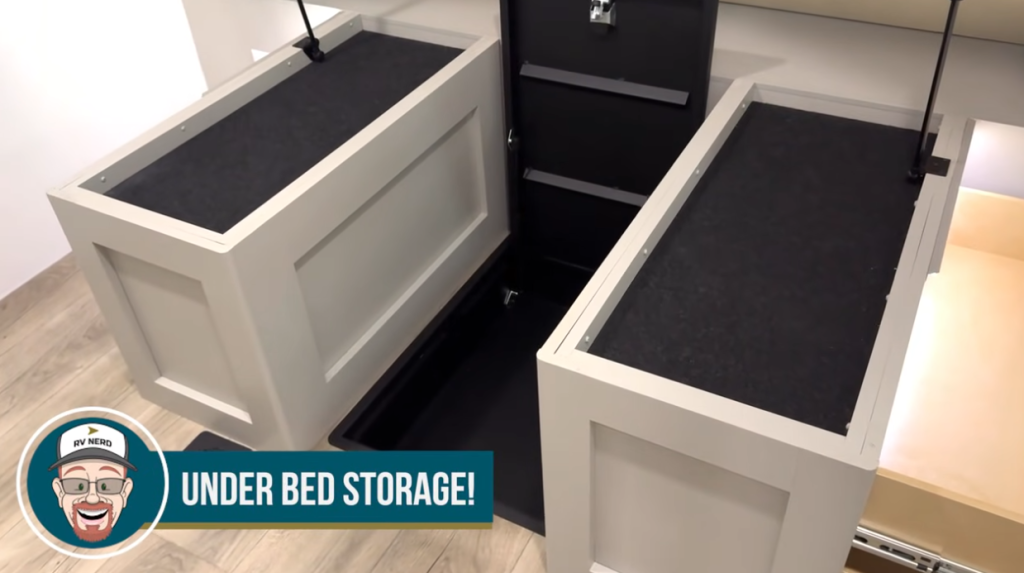 Under-bed storage system in the 2026 Brinkley Model Z Air showing lift-up gas-strut panels, finished storage compartments, and deep recessed space for additional gear.