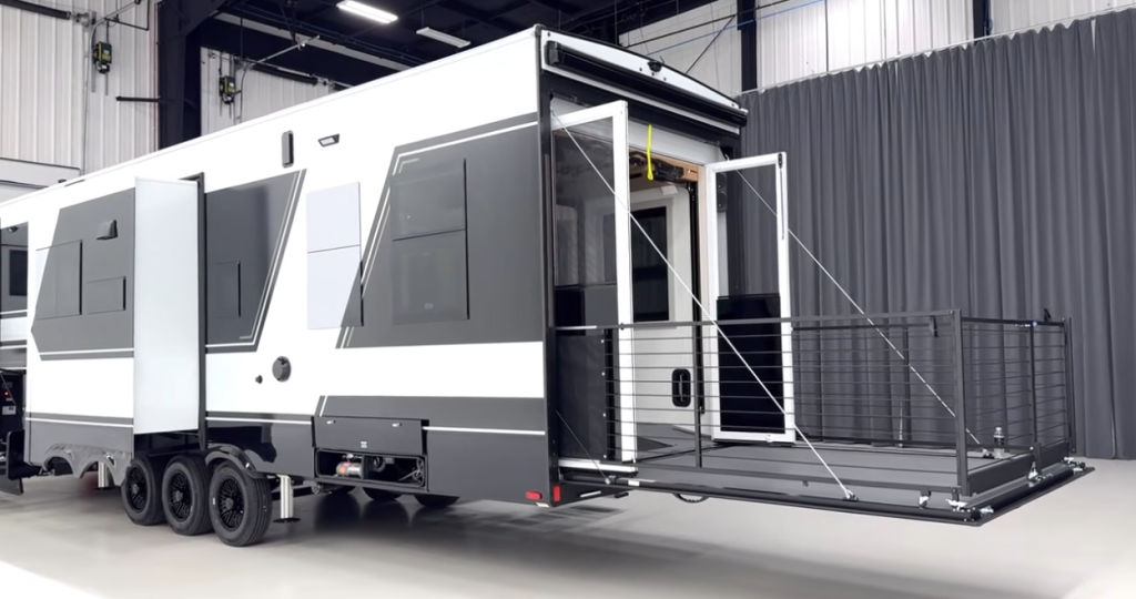 Brinkley toy hauler fifth wheel with triple axles shown with rear patio deck fully deployed, featuring modern exterior design and spacious garage access.