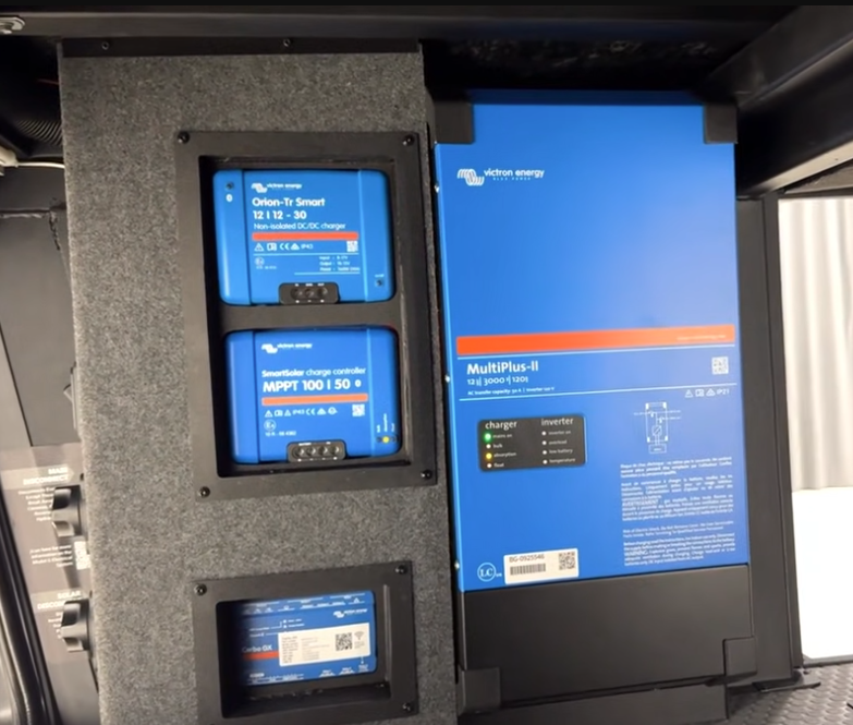 Victron Energy RV power system featuring a MultiPlus-II inverter/charger, SmartSolar MPPT charge controller, and Orion-Tr Smart DC-DC charger mounted in a dedicated electrical bay.