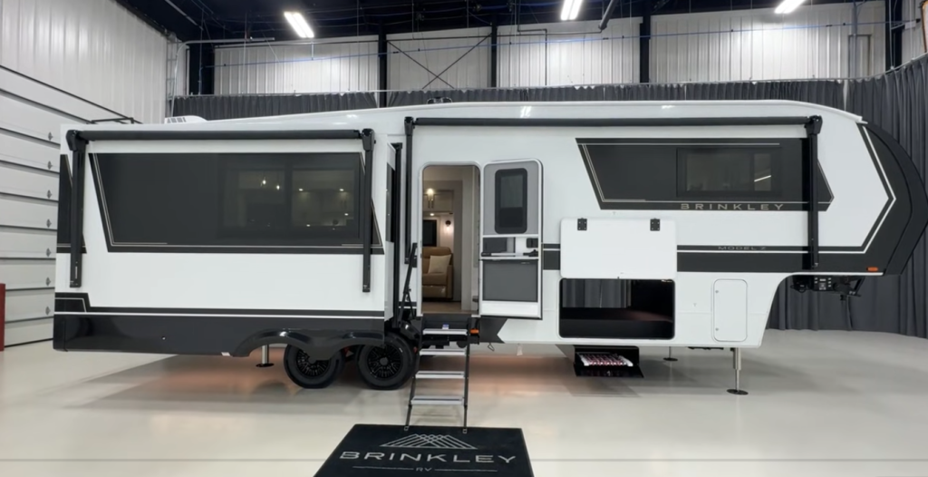 Brinkley Model Z 3200 fifth wheel exterior view with dual slide-outs, large tinted windows, fold-down steps, spacious pass-through storage, and modern luxury RV design.