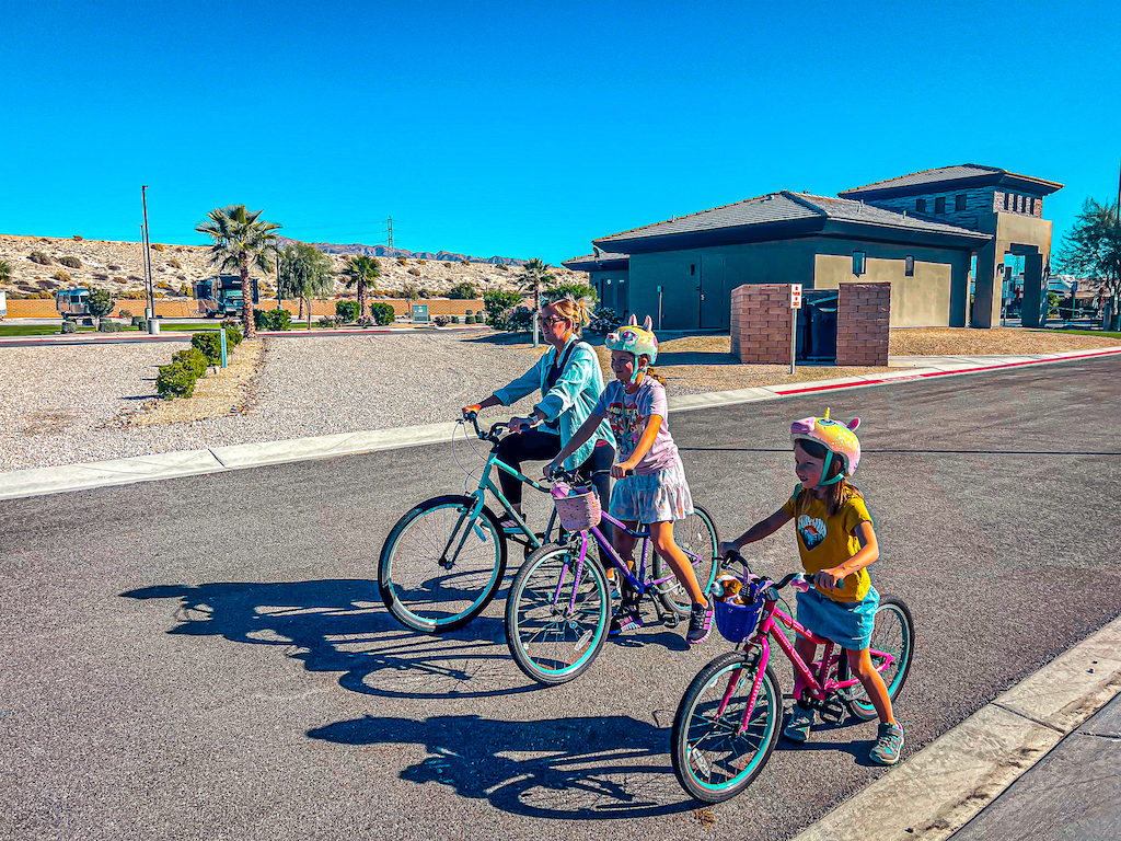 family riding bikes in campground