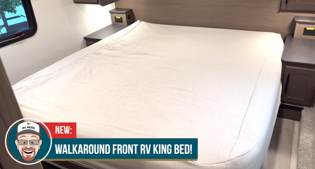 Walkaround front RV king bed with residential mattress, bedside nightstands, and overhead storage, offering easy access on both sides and comfortable sleeping space for full-time RV living or extended travel.