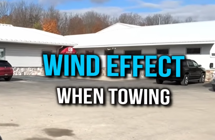 RV towing safety graphic with text reading “Wind effect when towing” at an RV dealership lot