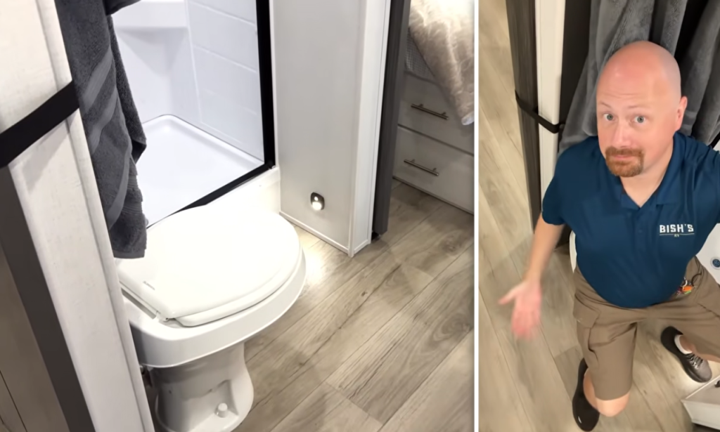 RV bathroom with toilet, shower, and wood-look flooring while Bish’s RV staff member demonstrates space