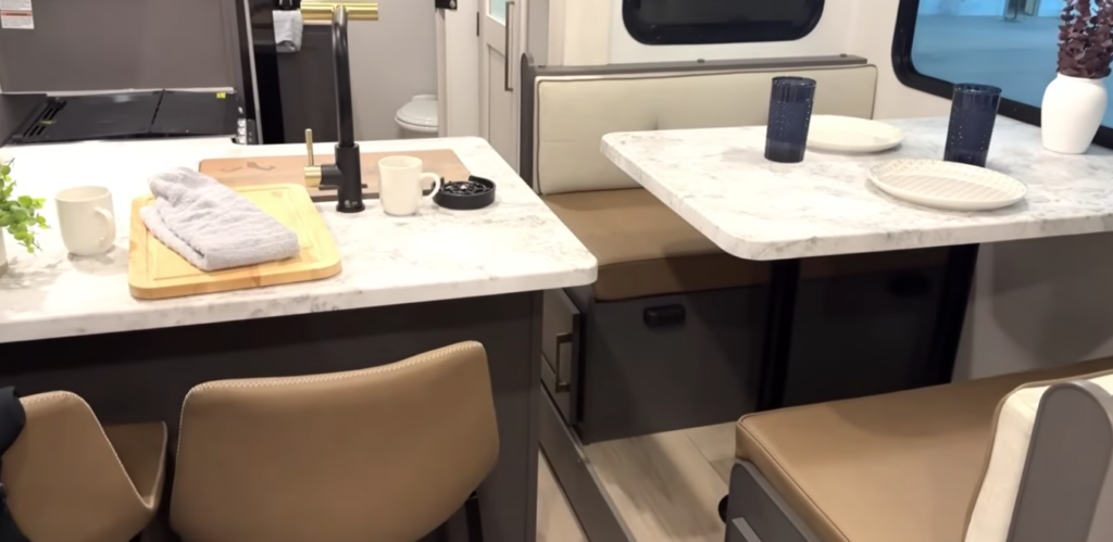 Travel trailer kitchen counter and dinette with seating and table setup