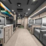 Interior of Grand Design Lineage Series F motorhome showcasing spacious living area, residential-style kitchen, and premium finishes for a luxurious travel experience.