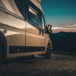 A close up of a class B motorhome's side as it faces the sunset.